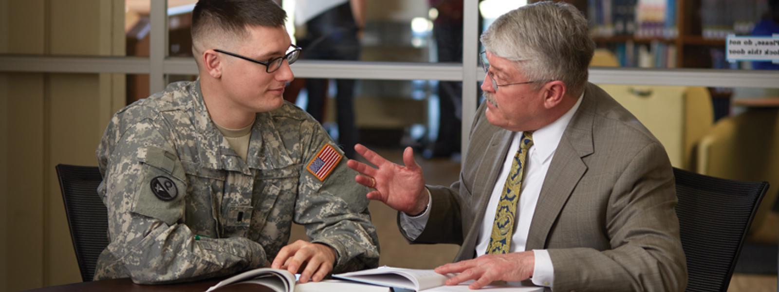 一位神学院教授在办公室环境中与一名军队牧师学生谈话.